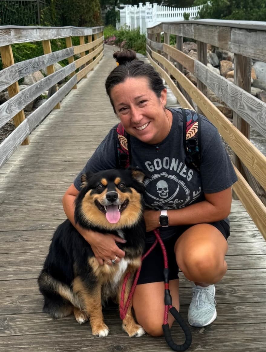 Jenny on a wooden footbridge with her dog.